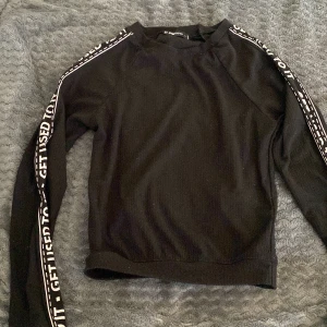 Svart tröja med tryck - Svart tröja med tryck på ärmarna. S