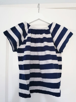 Randig t-shirt - Marinblå- och vitrandig t-shirt med resår i kragen. Bra skick!