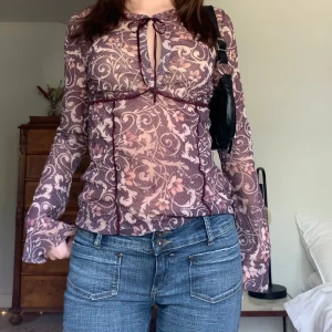 Mönstrad meshblus - Fin blommig blus i mesh med rosetter vid halsen och slutet av ärmarna, från märket Mexx! 💗