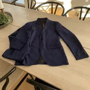 Mörkblå kostym i storlek ”m” för endast 400kr! Kostymen är från Jack and Jones  och både jacka och byxor ingår. Settet har endast användts en gång.