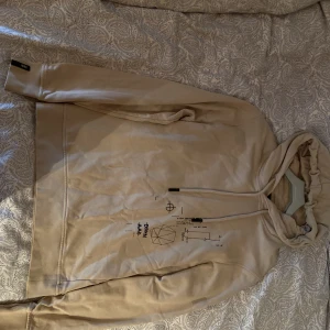 Beige DRKN hoodie. - En riktigt fräsch beige DRKN hoodie. Tryck på framsidan, inget på baksida eller på armarna. Aldrig använd, mycket bra skick. Skick 10/10.