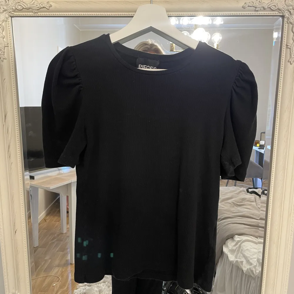 En svart T-shirt med puffiga axlar och superskönt material💗 lite nopprig vid innerarmarna se bild 3❣️storlek L men är liten i storleken . T-shirts.