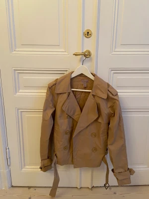 H&M vintage trenchcoat - H&M Trend cropped trenchcoat. Storlek M men passar mer som S. Lite skrynklig på bilder men går att strykas bort. 