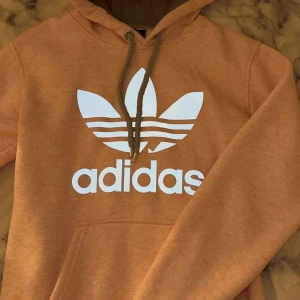Adidas hoodie  - Säljer en adidas hoodie, den är rosa (som på andra bilden). Den har en defekt på märket men är annars i toppen skick💗Den är i storlek M men är liten i storlek (Xs/S).