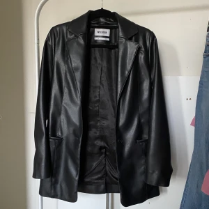 Oversized kavaj Weekday - Svart oversized skinnkavaj (imitation, vegan). Toppskick!  Inköpt för 700 kr, säljer för hälften. 