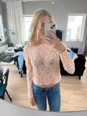Spetstopp  - Söt puderrosa spetsblus med liten puffärm. Knapp i nacken.