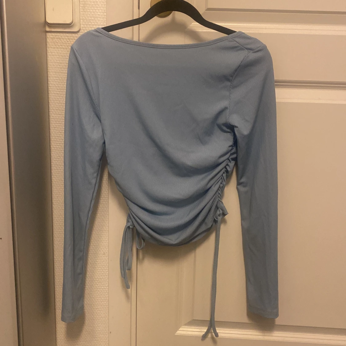 Säljer en blå långärmad tröja med ett knyt vid båda sidorna, väldigt skön att ha på sig och matchar till typ allt - 90