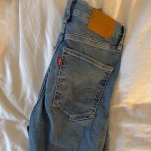Ett par Levis jeans med hål i ena knät. Tighta med lite slit längst ner. XS 