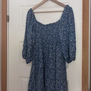 Klänning - Super fin klänning i bra skick! Blå med fina vit/ oranga kläder! Slutar vid knäna på mig som är 167cm lång. 