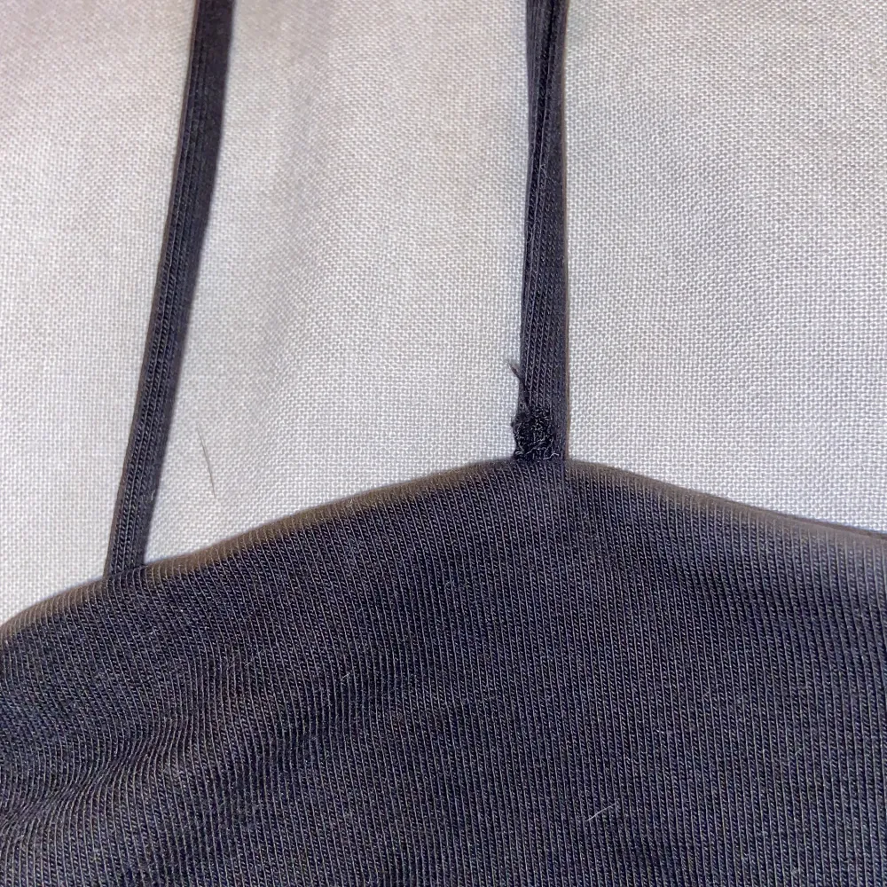 Ett svart basic ganska kort linne från Gina Tricot. Den är i använt skick men inget som syns förutom det lilla hålet i början av ena bandet. Det finns även ett extra tyg över bröstet under linnet!. Toppar.