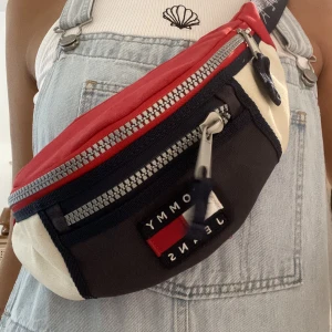 Tommy jeans Bum Bag - Tommy jeans Bum bag i blå , röd och vit. Justerbart band. Använd.  Finns tecken på blekning av färgen från ex sol. 