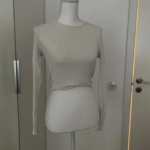 Vit tajt topp med öppen rygg - En vit topp som är tajt och har en öppen rygg. Använd 1 gång men kommer inte till användning mer därav säljer jag den. Från newyorker
