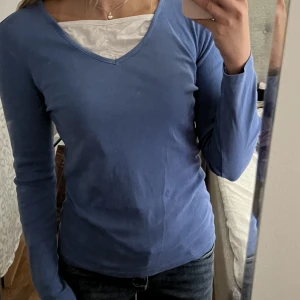 Långärmad blå tröja - Galet söt långärmad blå tröja med linne detalj. Begagnat fint skick, inga fläckar eller hål! Passar S🫶💕