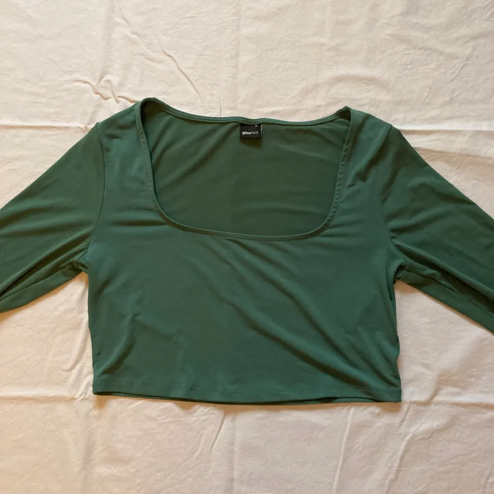 Grön croppad långärmad blus från Gina Tricot, köparen står för frakten och priset går att förhandla. Blusar.