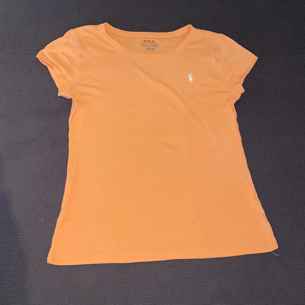 Sjukt fin t shirt som är figurnära och i en mycket fin aprikos färg! Färgen syns inte alls bra på kamera men är orange-rosa (lite mer rosa irl). Köpt för dryga 600kr i Florida. . T-shirts.