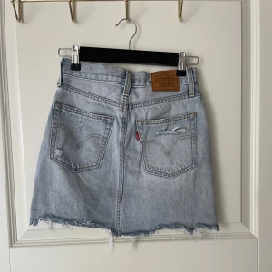 Levis kjol - Levis kjol i ljus denium med slitningar. I storlek 23 passar xs.