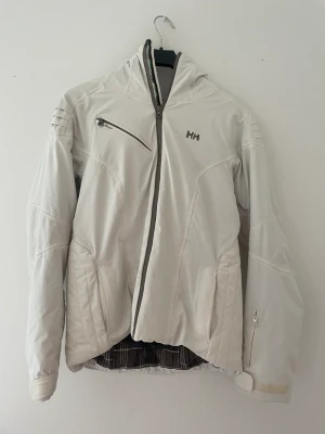 Helly Hansen Vinterjacka  - Vit vinterjacka/skidjacka från Helly Hansen. Varm och sitter snyggt runt midjan