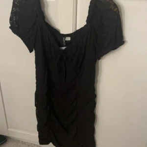 Klänning  - Svart söt klänning med spets. Helt oanvänd med prislapp kvar. Säljer då den inte kommer till användning. 