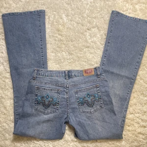 Lågmidjade Bootcut jeans  - Lågmidjade Bootcut jeans med fina detaljer köpta i usa! Jätte bra skick. Innerbenslängd:78 midjemåttet 38. Vill du köpa trycker du på ”köp nu” jag postar alltid samma dag eller dagen efter köp.