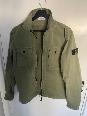 Stone island overshirt - Hej, jag säljer nu min stone island overshirt i färgen grön eftersom att den är lite för liten för mig. Storlek 14 år, passar S. Endast använd fåtal gånger så väldigt bra skick. Köpt för nypris på cirka 4500kr. Pris kan diskuteras!