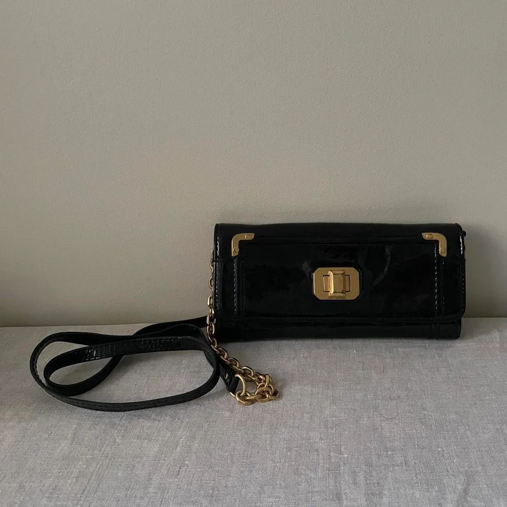 Juicy Couture Black Patent Leather Crossbody  Black fabric Lining/Golden Hardware with minimal branding  Removable Black Leather/Golden Chain Strap, can be used as wallet  1 Exterior Compartment 5 Interior Compartments & 1 Zip Pocket 6 Card Inserts. Väskor.