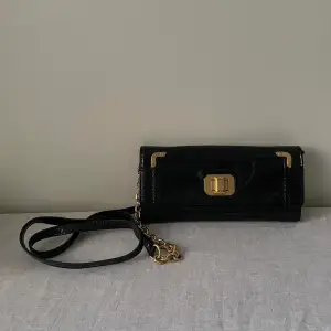 Juicy Couture Black Patent Leather Crossbody  Black fabric Lining/Golden Hardware with minimal branding  Removable Black Leather/Golden Chain Strap, can be used as wallet  1 Exterior Compartment 5 Interior Compartments & 1 Zip Pocket 6 Card Inserts