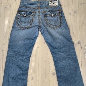 True Religion Jeans - Säljer mina super snygga baggy True Religion Jeans med cool tvätt som är bootcut!!! Midjemått tvärs över: 40cm, Innerbenslängd: 83cm. Skriv om du har några funderingar!