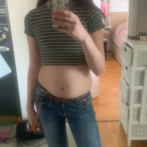 Ribbad, croppad t-shirt - Denna t-shirt är min syrras gamla. Märket är pull & bear. Den är några år gammal. Den är i storlek S men skulle säga att den är lite tajtare så kanske Xs. Föreslå gärna ett pris!