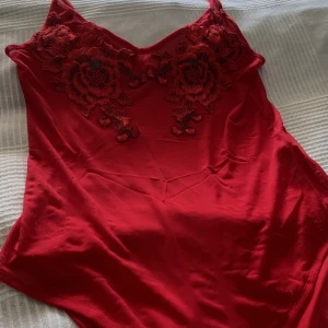 Body - Har hållit hårt i denna body, men tyvärr så lär den säljas nu! Röd body, med rosor på bröstet! Fruktansvärt fin!