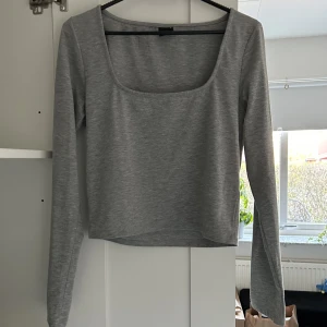 grå långärmad - grå långärmad tröja med kvadratisk urringning. bra skick och har inga defekter.
