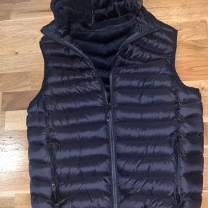 Svart väst - Säljer en svart väst från Shein storlek S, har aldrig använt denna då den var stor för mig. Skick 10/10. Huvan kan även tas bort och sättas på