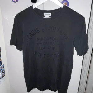 Zadig & Voltaire T-shirt - Säljer denna svarta Zadig Voltaire T-shirten i storlek XS men är som S. Den är försiktigt använd och köptes för ca 950kr. Texten har textur. Skriv om du vill ha fler bilder, pris kan diskuteras! Kan mötas i Stockholm annars står köparen för frakten!!❤️💖