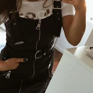 Svart klänning  - Säljer denna supersnygga skinnklänningen (inte äkta såklart). Har mycket fina detaljer. Den har tyvärr aldrig använts och lappen sitter kvar så precis som ny. Snygg att ha som den är eller med en T-shirt under🖤 köpt för 700kr.