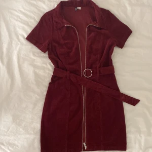 Klänning - Kort vinröd Manchester tyg klänning från Hm som har använts endast två gånger. Det står strl 42, men passar mig också som har 38 (M). Kontakta vid frågor!