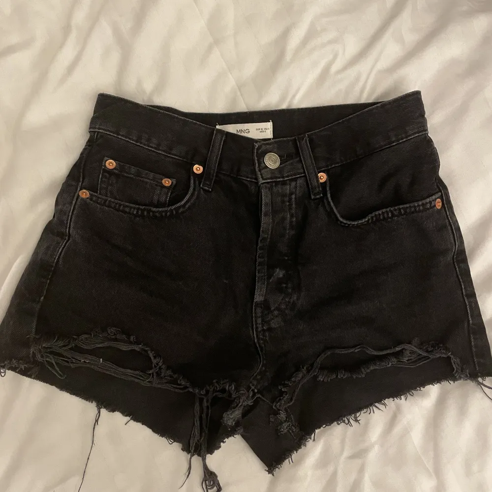 Säljer dessa mörkgråa jeansshorts ifrån Mango i stl 32, köptes sommaren 2022 och säljer då dom är för små på mig!😍. Shorts.