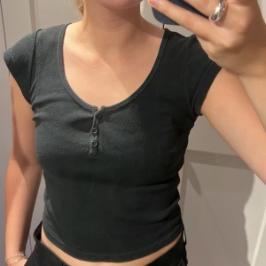 brandytopp - enkelt svart topp med knappar i halsen från brandy. 