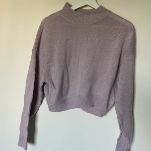 Lila stickad magtröja  - Knappt använd där med nyskick, den är pastel lila. 