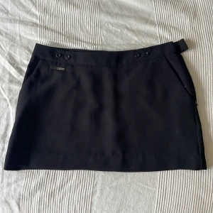 Svart tajt kort kjol - Säljer denna super snygga korta kjol som är så fin!! Den är helt ny och oanvänd. Från märket by malene birger som är super lyxigt! Man kan även spänna den där bak så man slipper de där hacket som man kan få när de sitter för löst i midjan, säljer billigt!