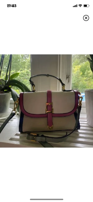 Väska - En söt liten väska i beige/off-white med rosa och mintgröna detaljer. Aldrig använd. Har endast stått på en hylla i min garderob. Köpt för 58 dollar plus frakt och tull. Säljes för 200kr. Fler bilder kan skickas vid förfrågan 