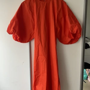 Fin sommarklänning HM - Orangeröd klänning från hm med dramatiska ärmar. Oanvänd, säljes pga för stor.