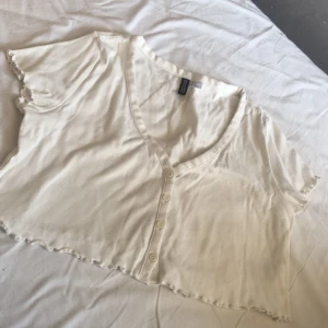 FIN VIT BLUS MED ETT V - Jätte fin blus köpt från H&M . Alla kläder tvättas innan jag postar,möter upp. STORLEK: M 