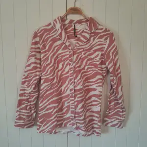 Rosa pyjamas skjorta med vita tiger ränder. Dam storlek small/xs. Endast använd ett fåtal gånger och i bra skick! Hör av dig om du vill köpa tillsammans med byxorna!