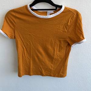 Orange cropped T-shirt. Använd fåtal gånger. Frakt tillkommer