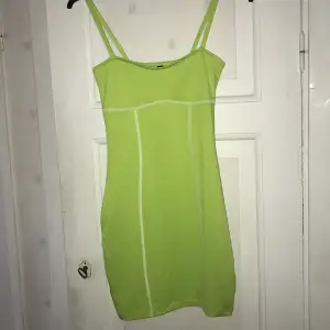 figursydd klänning från h&m använd en gång detaljsömmar längs kroppen går ner till halva låren  den är limegrön, lite liknande en tennisboll