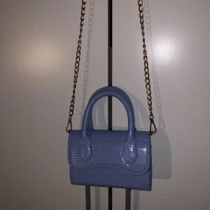 Blå väska  - En blå väska, med en guld kedja 