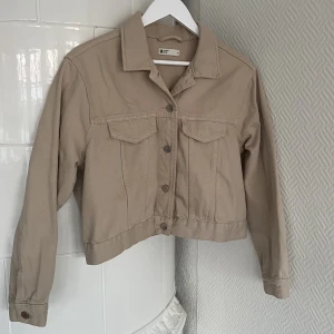 Beige jeansjacka - Snygg croppad jeansjacka från Gina Tricot i storlek M, endast använd en gång! 🤎