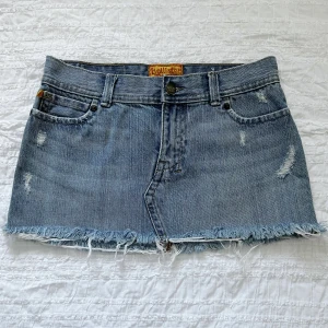 Jeanskjol kjol y2k - Jeanskjol från Hollister, fina detaljer på fickorna, använda ett fåtal gånger och i bra skick (Några glitter stenar saknas på ena bakfickans som du kan se på bild 3). Storlek 0. Midjemått 72 cm, framsidans längd ca 25 cm, baksidans längd ca 29 cm. 