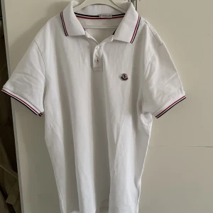 Moncler piké  - En vit moncler piké med nypriset 2800kr storlek L  