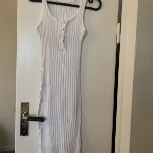 Slim vit klänning - Sommarklänning som är i färgen vit. Den är väldigt slim därav ser knapparna lite snea ut på bilden. Den framhäver figuren väldigt bra. Storlek M men tror att någon i storlek S och L också kan ha den