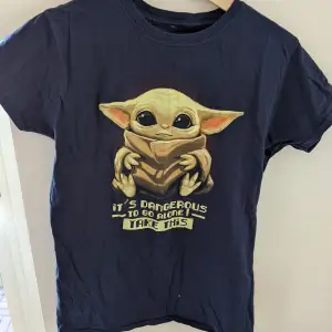 En jättegullig tröja med baby Yoda som motiv, och texten 